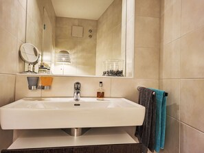 A bathroom with a large sink, a mirror, a towel rack with towels, and a window with a view of the outside. - Splendid Maggiore View by Interhome (Magadino)