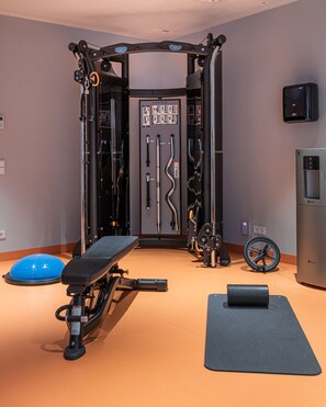 A gym with a squat rack, bench, and exercise balls. - URBAN LOFT Cologne (Cologne)