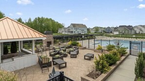 Un espace extérieur aménagé avec une terrasse, des sièges et une piscine.