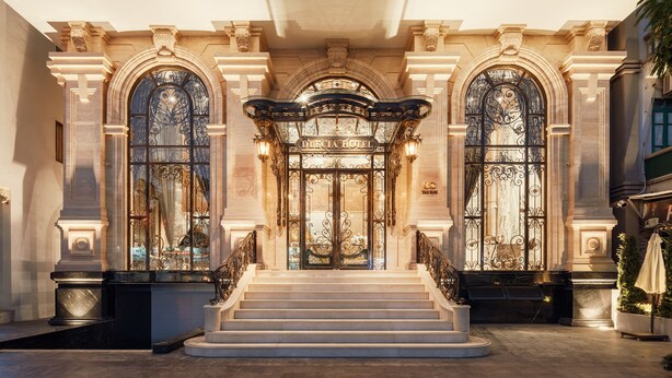 Una entrada imponente con una escalera que conduce a una puerta con el letrero "DOLCE HOTEL".
