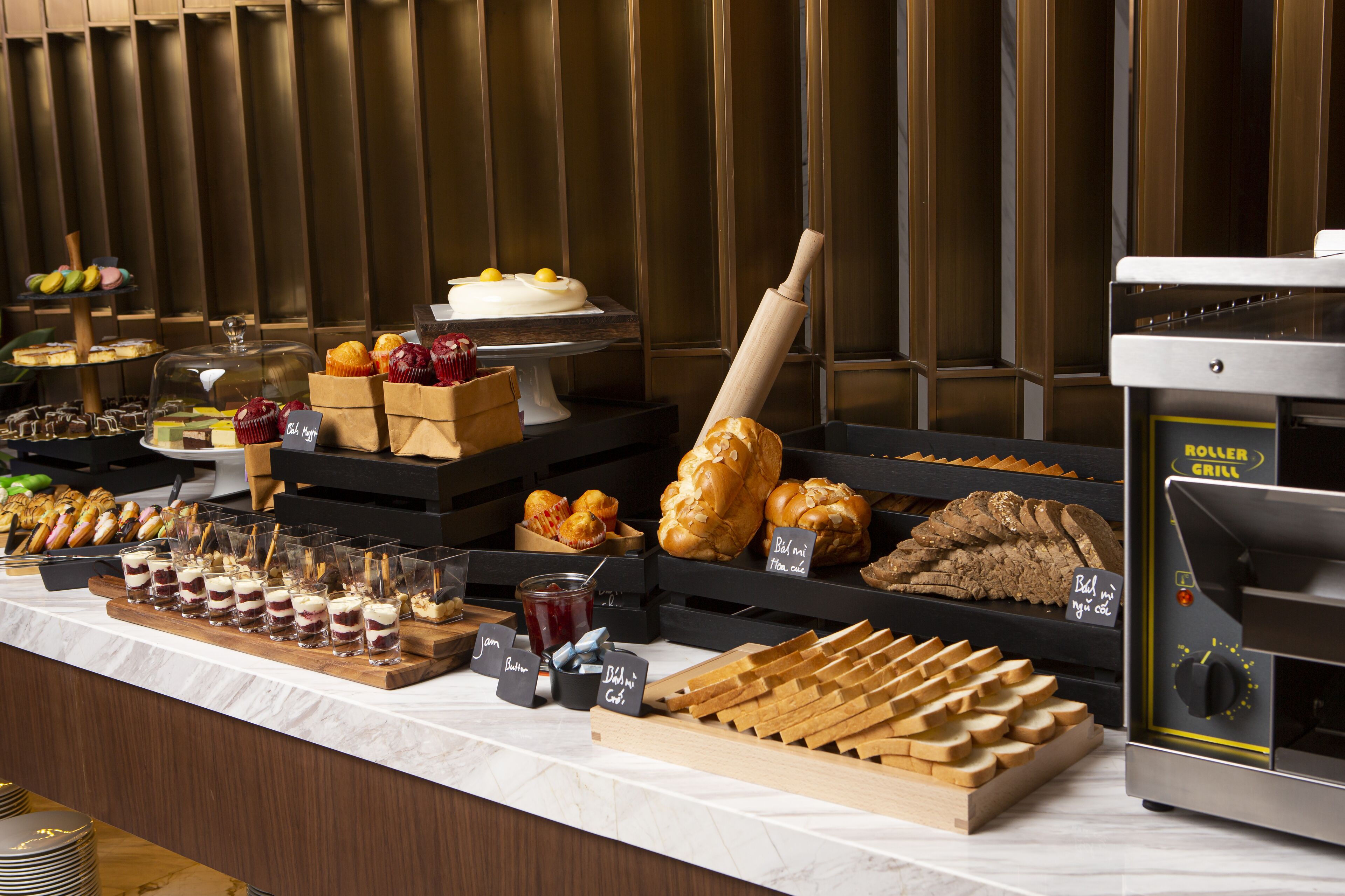 A buffet with various food items including pastries, sandwiches, and desserts.