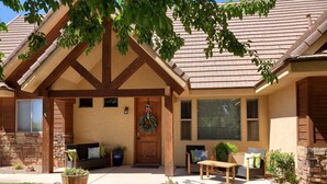 A house with a stone foundation, a wooden porch, and a covered entryway.