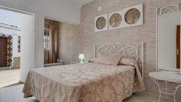 Une chambre à coucher avec un lit, une table de chevet, une lampe et un miroir fixé au mur.