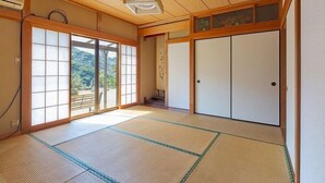 A traditional Japanese room with tatami flooring, sliding doors, and a ceiling fan. - Sasayakana Ouchi Fuuki (Futtsu)