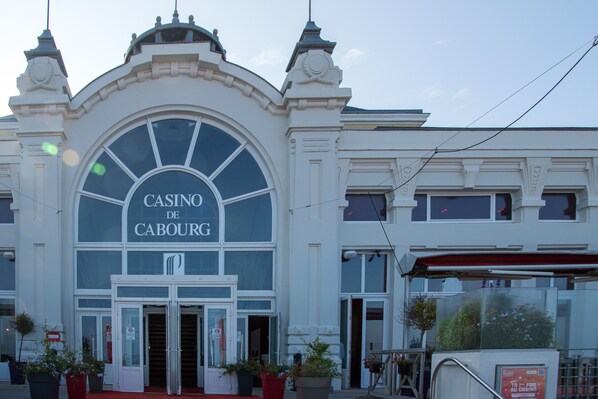 A building with a large arched entrance and the sign "CASINO DE CABOURG". - Beautiful apartment—50 meters from the ocean (Cabourg)