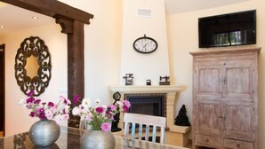 Una sala de estar con chimenea, un reloj y un aparador de madera.
