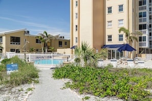 Un hôtel doté d’une piscine, d’un espace extérieur aménagé et d’une enseigne indiquant l’adresse.
