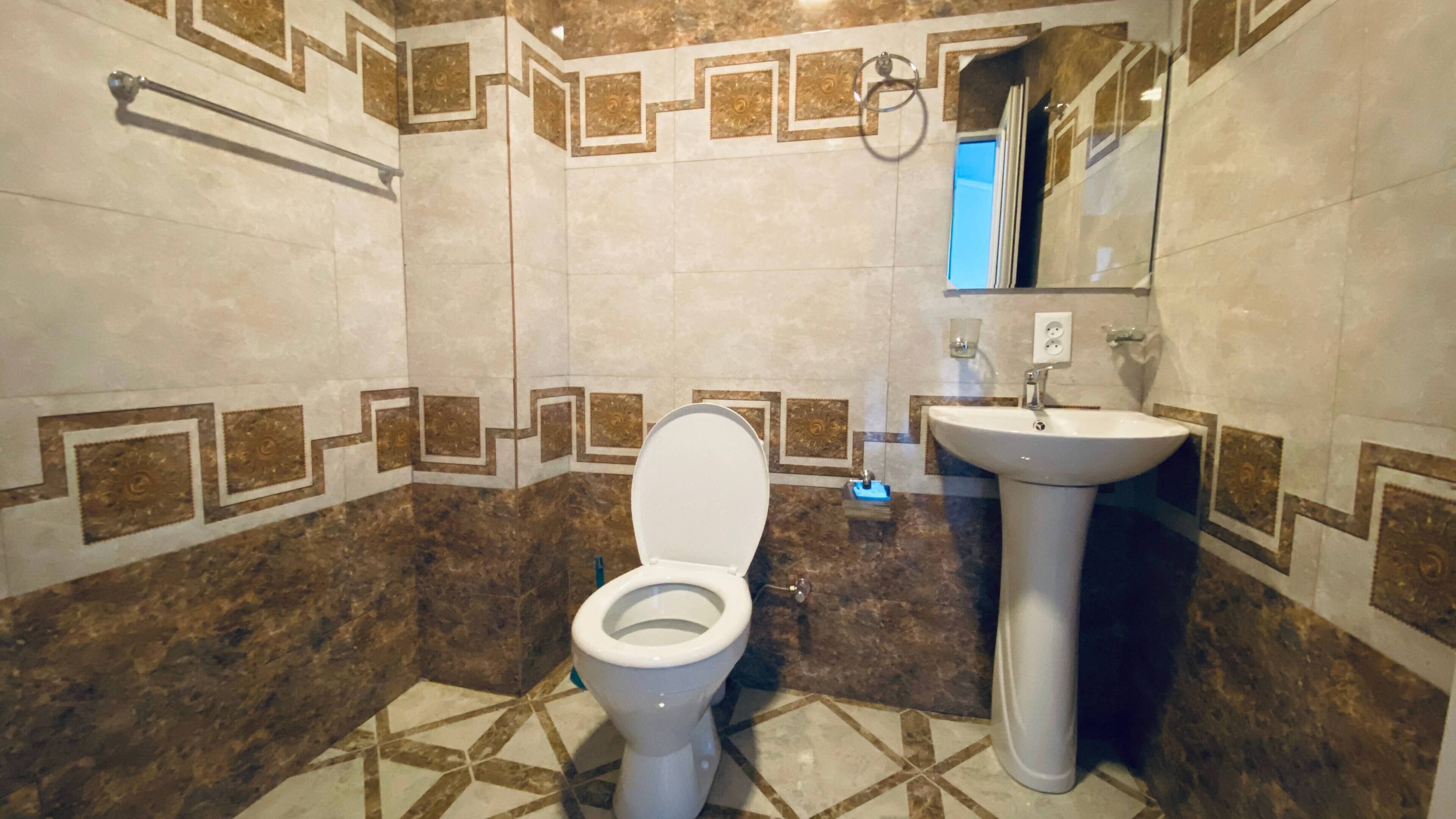 Un baño con inodoro, lavabo y espejo.