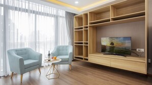 Un salon moderne avec un canapé, une table basse et un téléviseur posé sur un meuble en bois.