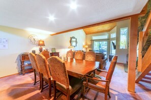A dining area with a wooden table and patterned chairs, a clock, and a lamp on a side table. - Beautiful, pet-friendly townhome w/ mountain views (Mammoth Lakes)