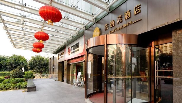A hotel entrance with a glass door, red lanterns, and a sign for the East Coast Hotel. - East Coast Hotel Guangzhou (Guangzhou)