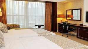 A hotel room with a large bed, a desk with a chair, a television, and a window with curtains. - East Coast Hotel Guangzhou (Guangzhou)