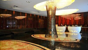 A luxurious lobby with a central column, multiple chandeliers, and a reception desk. - East Coast Hotel Guangzhou (Guangzhou)