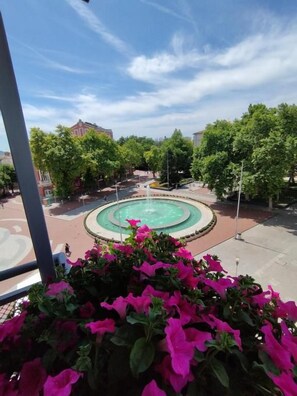 Un patio con una fuente, rodeado de árboles y edificios.