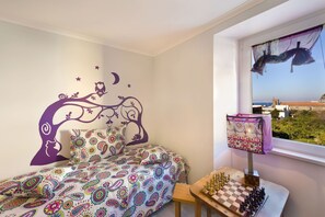 Een slaapkamer met een bed, een schaakbord en een muurschildering.
