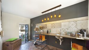 Una cocina moderna con pared oscura, salpicadero decorado y lámparas colgantes.