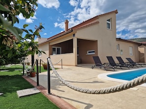 A building with a pool, lounge chairs, and a rope barrier. - Holiday Home near Trogir (Kastela)