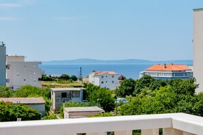 Un quartier résidentiel situé sur la côte, avec des bâtiments, de la verdure et une vue sur la mer.