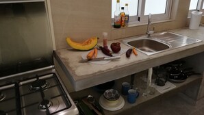 A kitchen with a stove, sink, and various kitchen items like vegetables and utensils. - 45C Coco Canopy Sea views Hiking Kiting Beaches Adventure (La Gaulette)