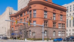 A historic building with a distinctive corner design, large windows, and a prominent entrance.