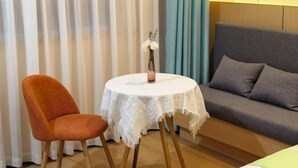 A room with a round table, a sofa, and a chair. - GreenTree Inn (Lezhi County Government Branch) (Ziyang)
