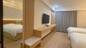 A hotel room with a bed, a TV, a desk, and a mirror. - GreenTree Inn (Lezhi County Government Branch) (Ziyang)