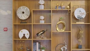 A wooden shelving unit with various decorative items including a globe, a bottle, and figurines. - GreenTree Inn (Lezhi County Government Branch) (Ziyang)
