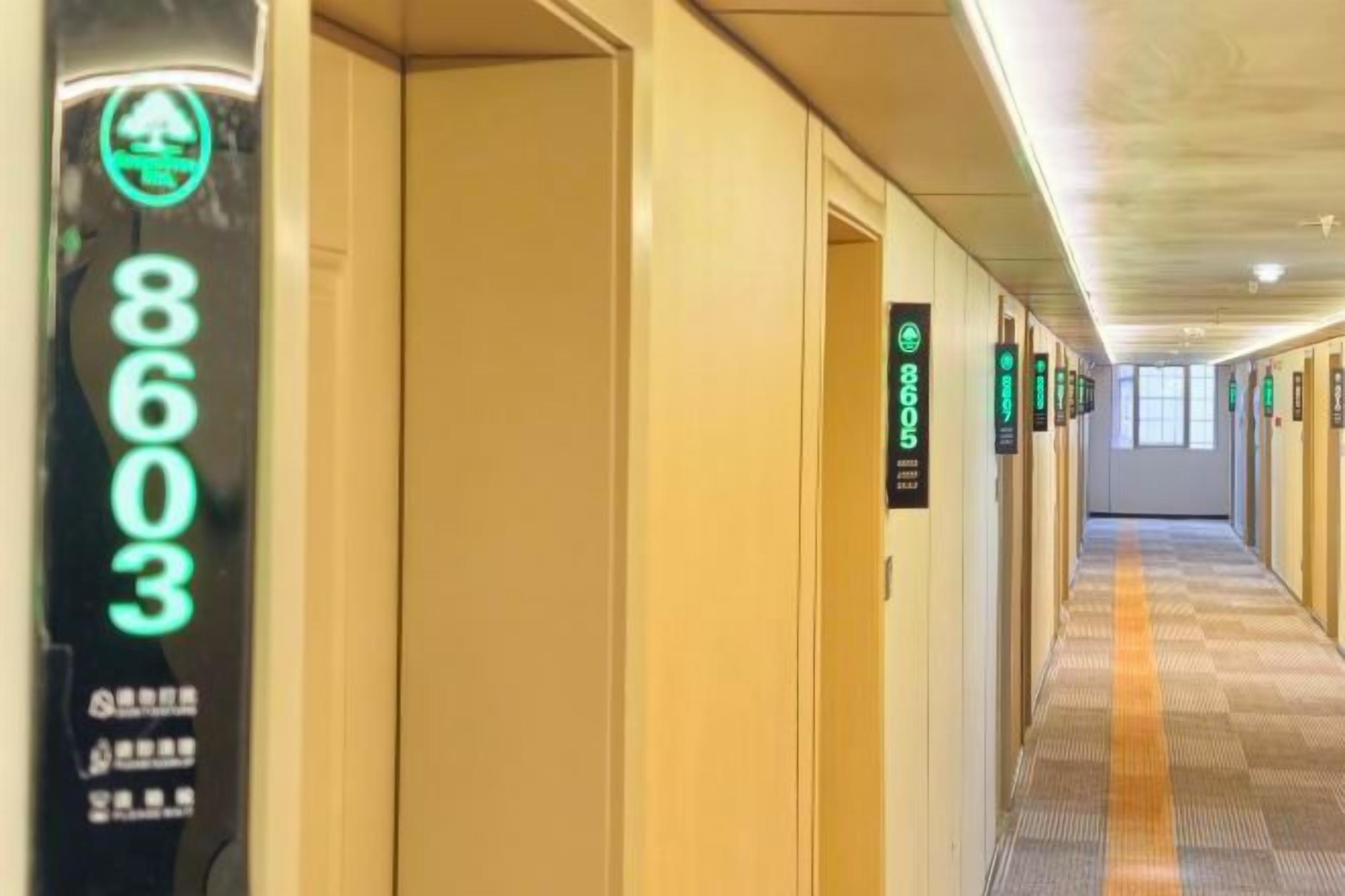Een hotelgang met deuren genummerd 8603, 8604 en 8605, en een vloerbedekking.