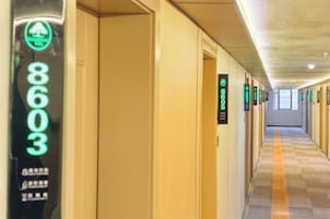 Pasillo de hotel con puertas numeradas 8603, 8604 y 8605, y suelo alfombrado.