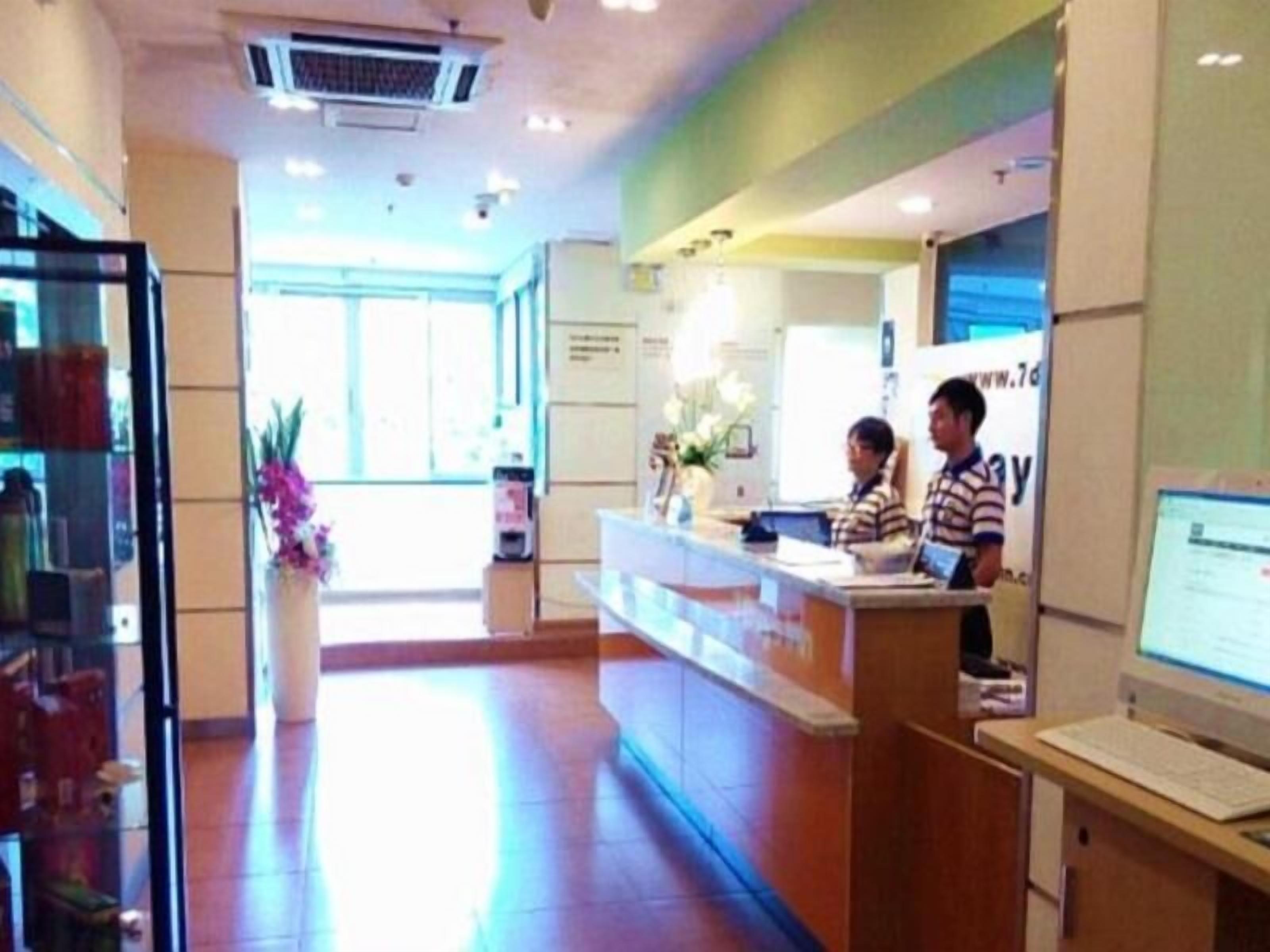 A reception area with a reception desk, a computer, and a window with a view of the outside.