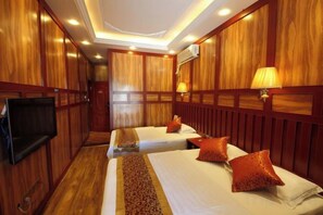 A hotel room with two beds, a television, wooden paneling, and a lamp. - Youjian Inn (Chongzhou)