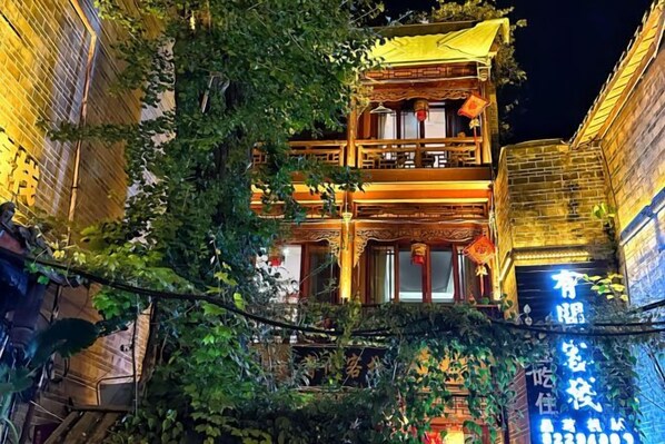 A traditional building with a balcony and a sign with Chinese characters. - Youjian Inn (Chongzhou)