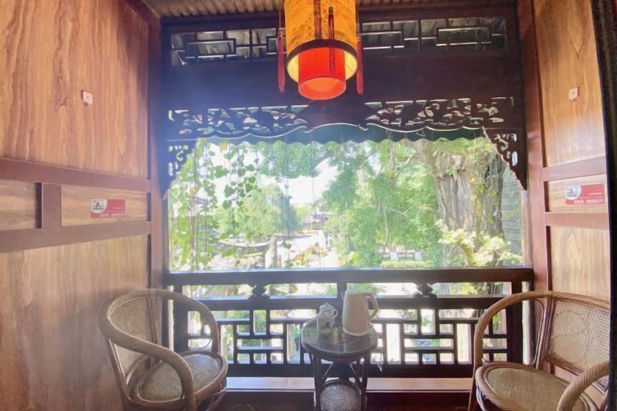 A traditional wooden interior with a view of greenery outside.