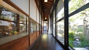 A corridor with wooden walls and large windows. - Uji Tea Inn (Uji)