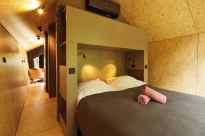 A modern hotel room with a built-in bed, a ceiling-mounted air conditioner, and a view of the hallway. - KampinaStaete (Oisterwijk)
