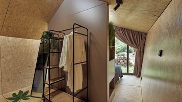 Une salle de bain moderne avec un plafond en bois, un porte-serviettes, une plante en pot et une vue sur l’extérieur.