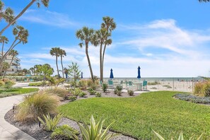 A landscaped outdoor area with pathways, palm trees, and seating areas.