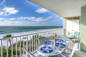 A balcony with a table set for two, overlooking a beach with a clear view of the ocean. - Updated! Beachfront, Private Balcony! Pool, Hot Tub, FREE Parking/FREE Activities! ~ 607 Sandcastle (Indian Shores)