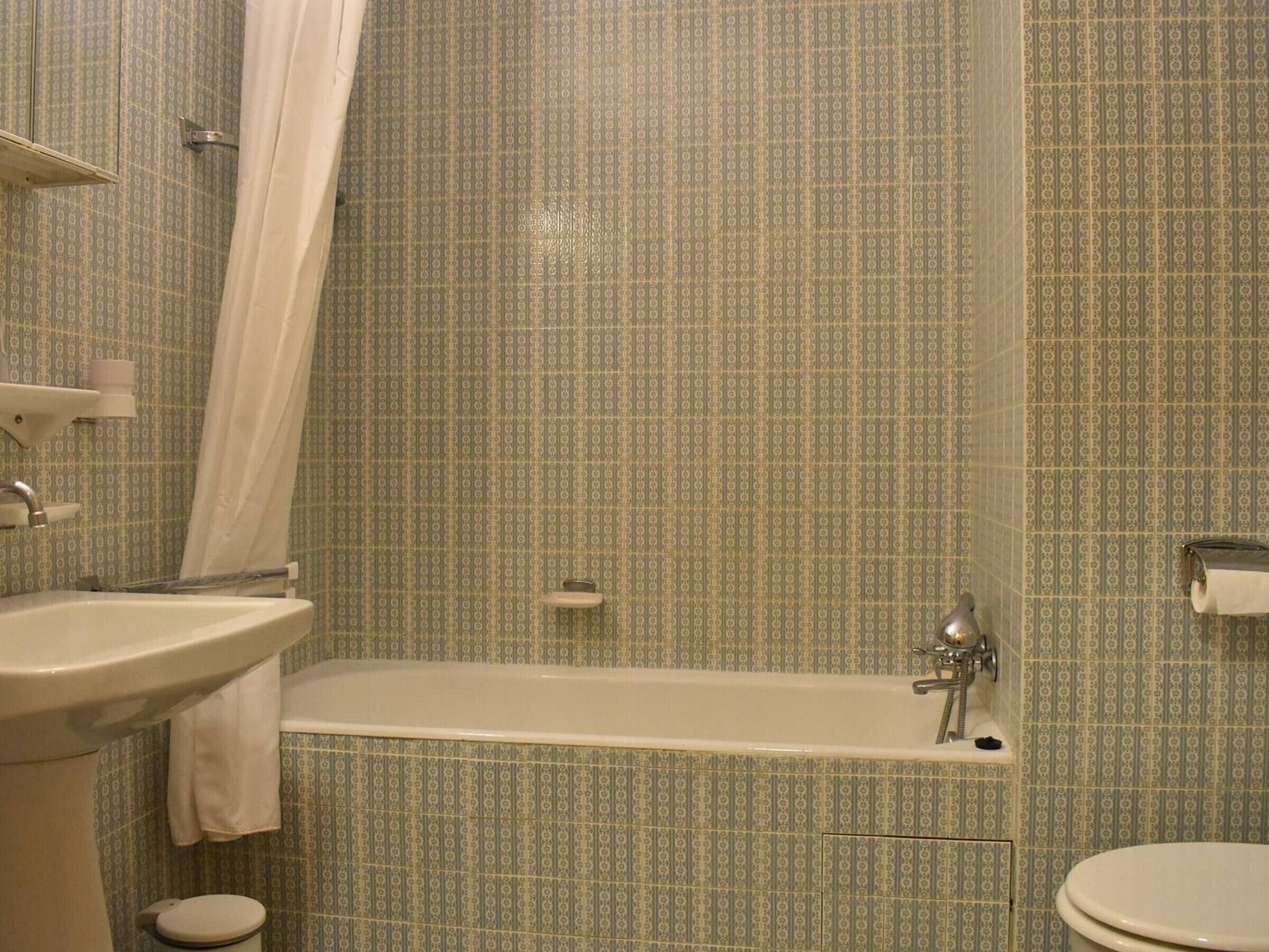 A bathroom with a bathtub, sink, and toilet.