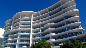 Un hotel de varios pisos con balcones en cada nivel, grandes ventanales y un diseño arquitectónico moderno.