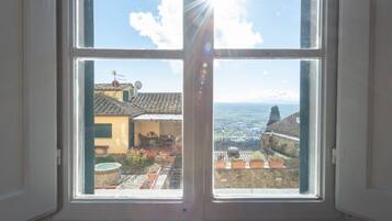 Una finestra con vista su un cortile e degli edifici.
