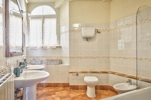 Ein Badezimmer mit zwei Waschbecken, einer Toilette und einer Badewanne.
