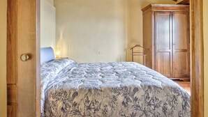 A bedroom with a bed, a wardrobe, and a wooden ceiling. - La Terrazza - apartment with breathtaking view (Cortona)
