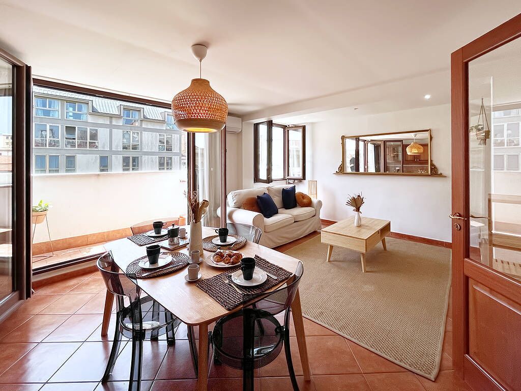 A modern apartment with a dining area, a sofa, and a small side table.