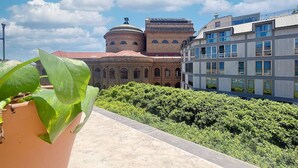 Un edificio con una cúpula y ventanas arqueadas, junto a una estructura moderna con ventanales amplios.