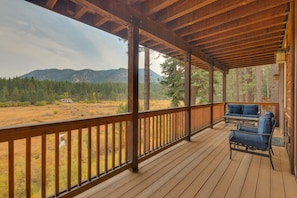 Una terraza de madera con vista a un paisaje montañoso.