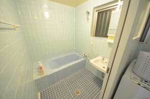 Un baño con bañera, lavamanos y ducha.