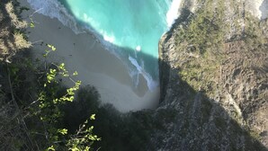 A coastal landscape with a beach, cliffs, and vegetation. - Relais Grottone (Ostuni)