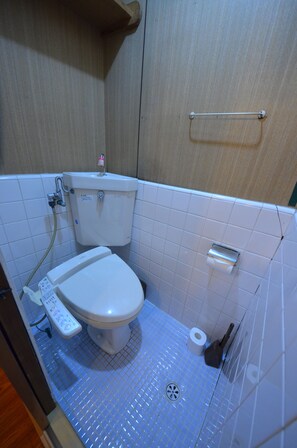 A small bathroom with a toilet, a hand dryer, and a paper towel dispenser. - Kyoto Kosakacho House (Kyoto)