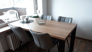 Un comedor con una mesa de madera, seis sillas y un centro de mesa geométrico.